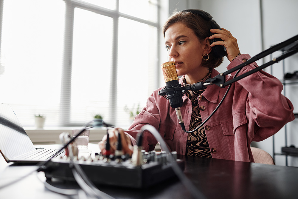 Woman speaking into a microphone for a podcast
